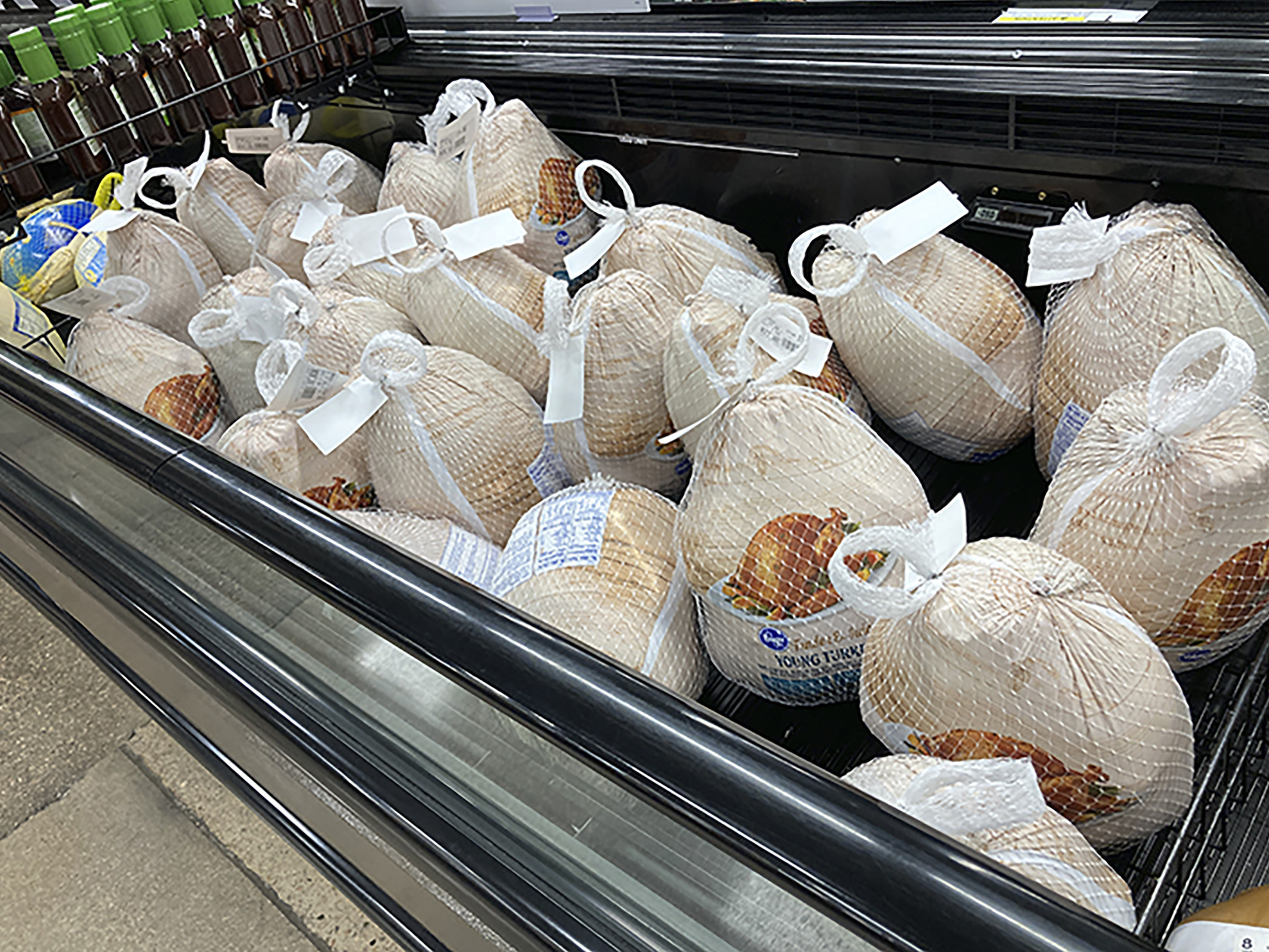 caption: Frozen turkeys sit in a refrigerated case inside a grocery store in southeast Denver. The Farm Bureau says high demand for meat and supply chain woes have increased the cost of Thanksgiving dinner this year.