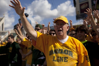 caption: Ken Starr cheers with Baylor University students before a 2012 game against the University of Kansas Jayhawks in Waco, Texas.