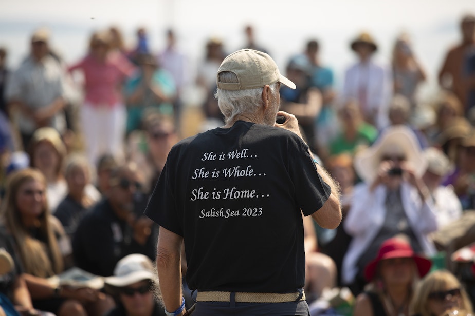 caption: Howard Garrett of Orca Network speaks to a crowd of hundreds during a celebration of life for Tokitae on Sunday, August 27, 2023, at Jackson Beach Park on San Juan Island. 