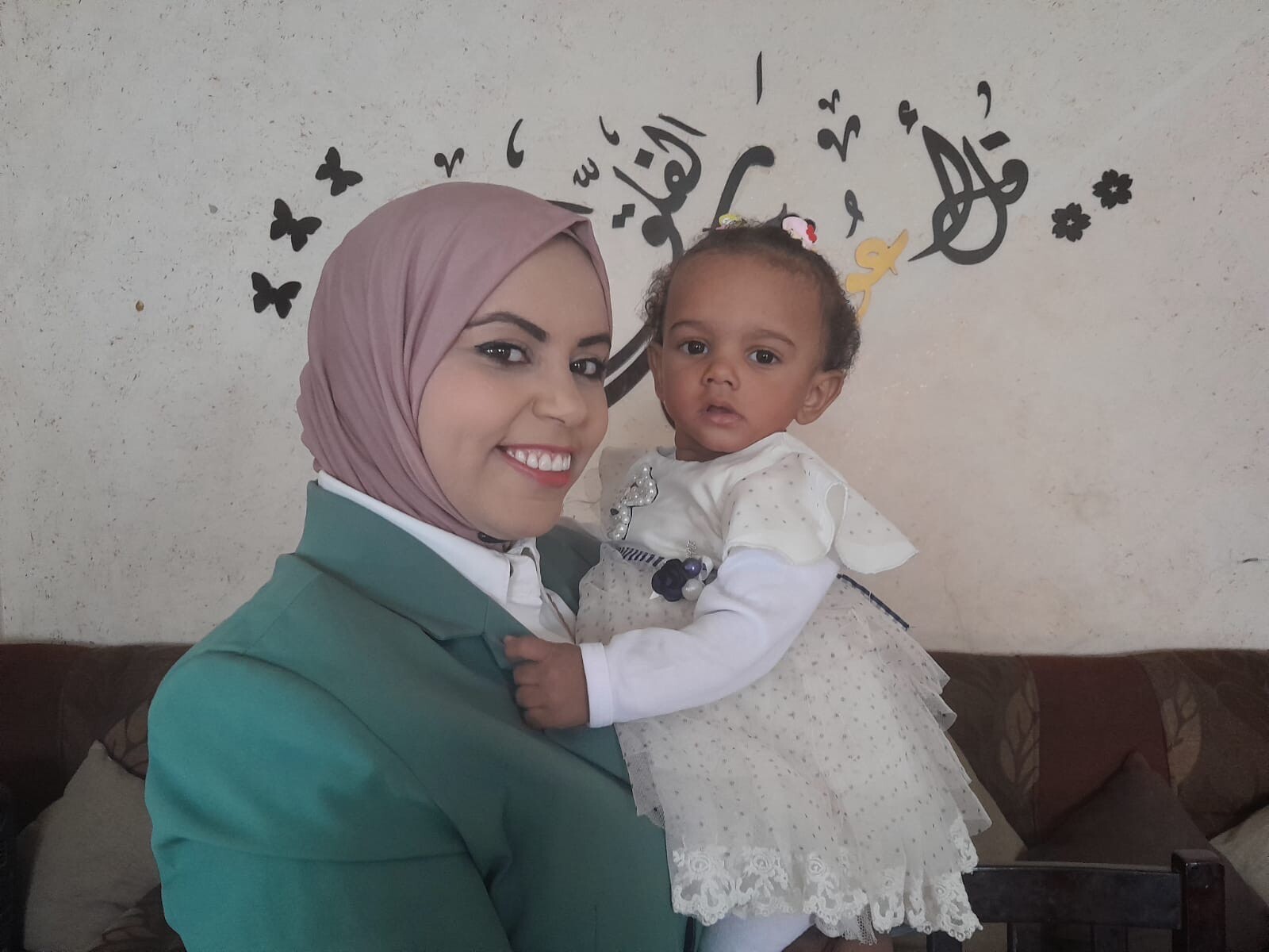 caption: Amal Abu Khatleh, a nurse at a Gaza hospital that admitted an unidentified infant last November, took the baby in and gave her the name Malak, meaning angel. Abu Khatleh holds Malak on her first birthday in October, in Deir al-Balah, Gaza Strip.