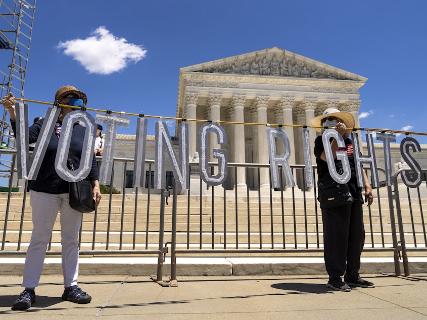 caption: Demonstrators hold up large cut-out letters spelling "VOTING RIGHTS" at a 2021 rally outside the U.S. Supreme Court in Washington, D.C.