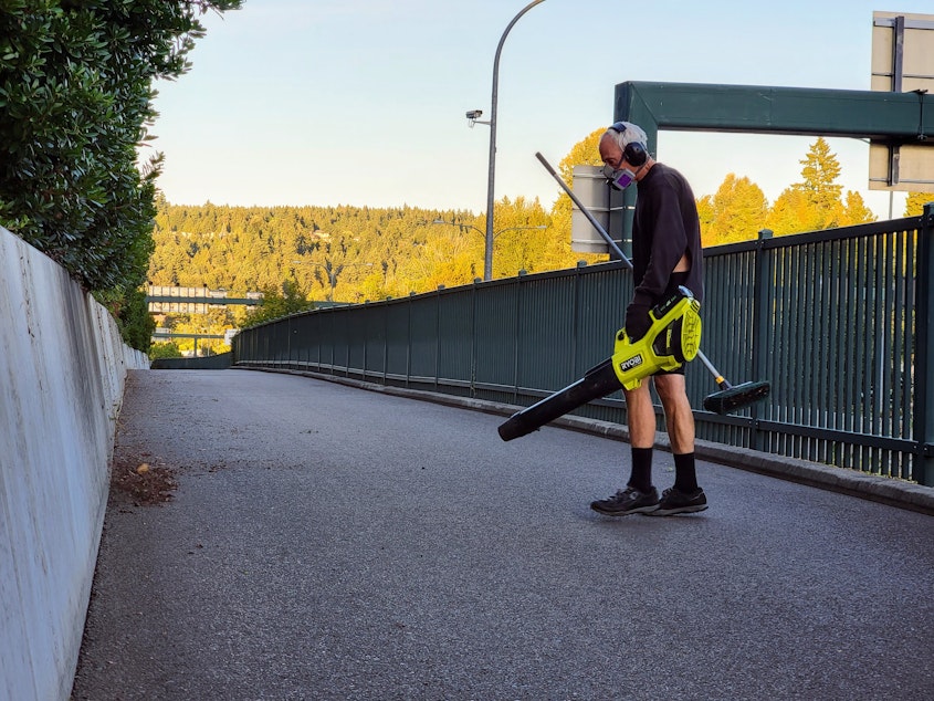 caption: Lee Zuhars uses his electric leaf blower on the 520 bike path on Wednesday, Sept. 13, 2023.