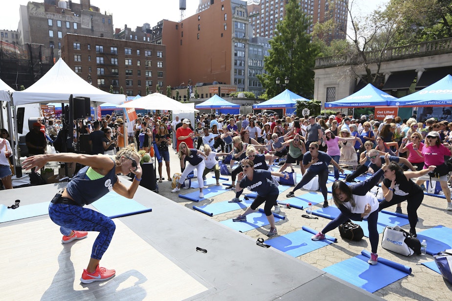 caption: At a WW GOOD wellness festival powered by Weight Watchers “WW” in Union Square, New York City residents engage in a movement and meditation series (“LIFTED”) led by Celebrity Fitness Instructor Holly Rilinger, Sunday, August 26, 2018. (Stuart Ramson/Weight Watchers via AP Images)