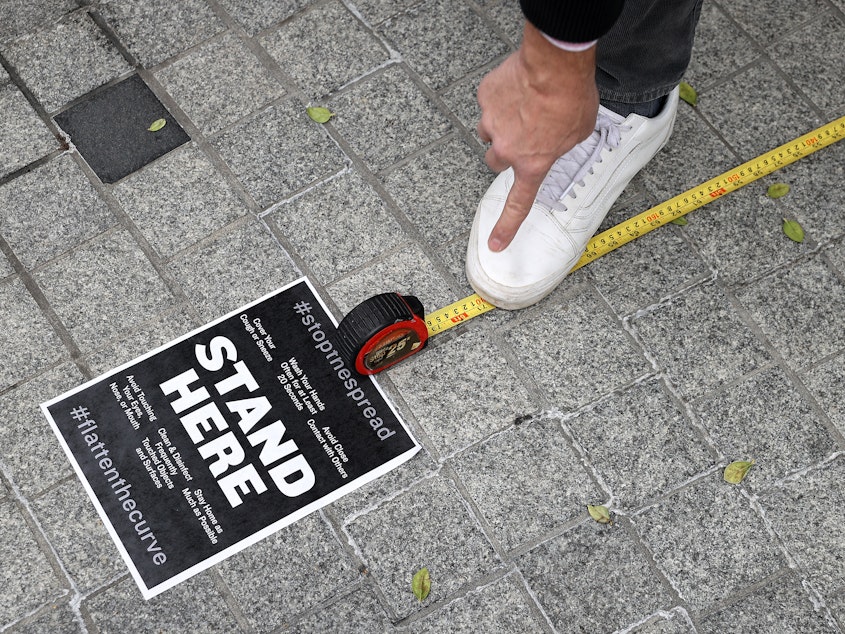 caption: Workers use a tape measure mark spaces six feet apart for people to wait in line safely as they convert the outdoor plaza in front of Zaytinya, one of Chef José Andres' restaurants in Washington, D.C. Efforts to contain the coronavirus are affecting blood donor drives and supplies.