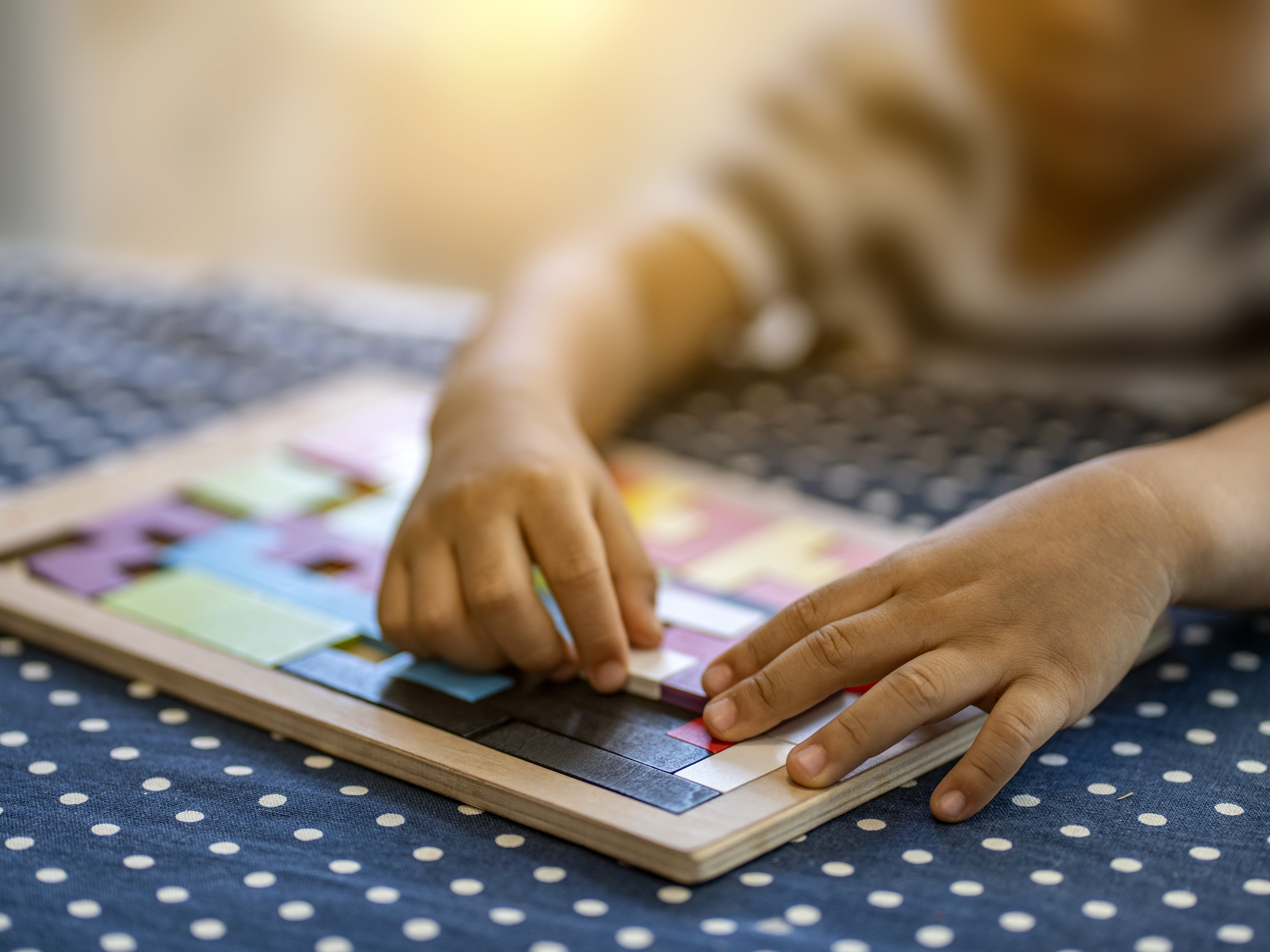 caption: A child plays with colorful plastic blocks. Children in need of quality childcare is in high demand but short supply, including for disabled children,  parents say.