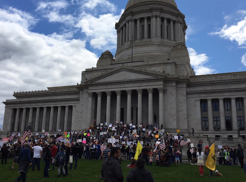 caption: On Sunday, crowds gathered at the Washington Capitol in defiance of and in opposition to Gov. Jay Inslee's COVID-19 orders restricting crowd sizes, shuttering businesses and requiring people to stay home.