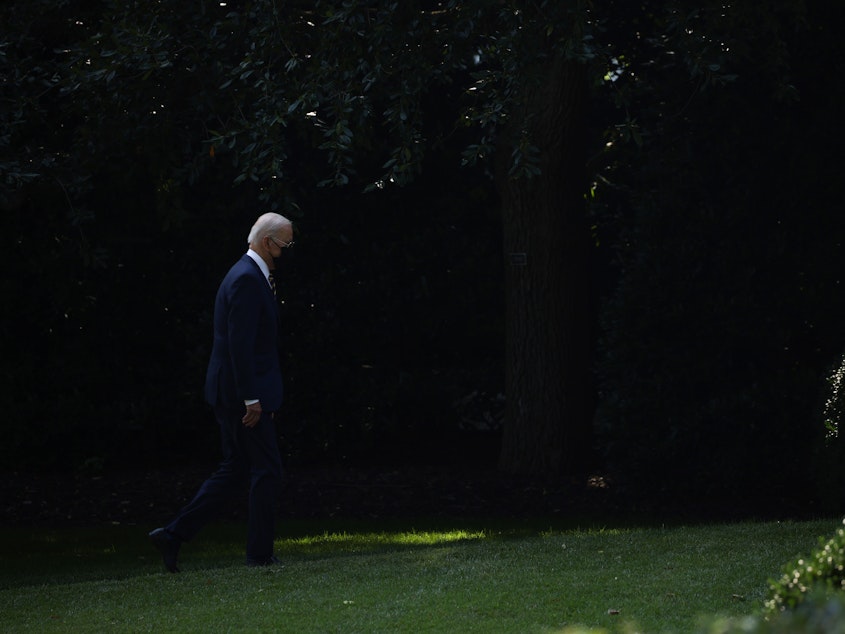caption: President Biden walks to the Oval Office after arriving on Marine One.