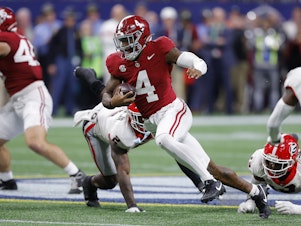 caption: Jalen Milroe of the Alabama Crimson Tide scrambles for a first down during the fourth quarter against the Georgia Bulldogs in the SEC Championship on Dec. 2, 2023 in Atlanta, Ga.