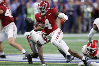 caption: Jalen Milroe of the Alabama Crimson Tide scrambles for a first down during the fourth quarter against the Georgia Bulldogs in the SEC Championship on Dec. 2, 2023 in Atlanta, Ga.
