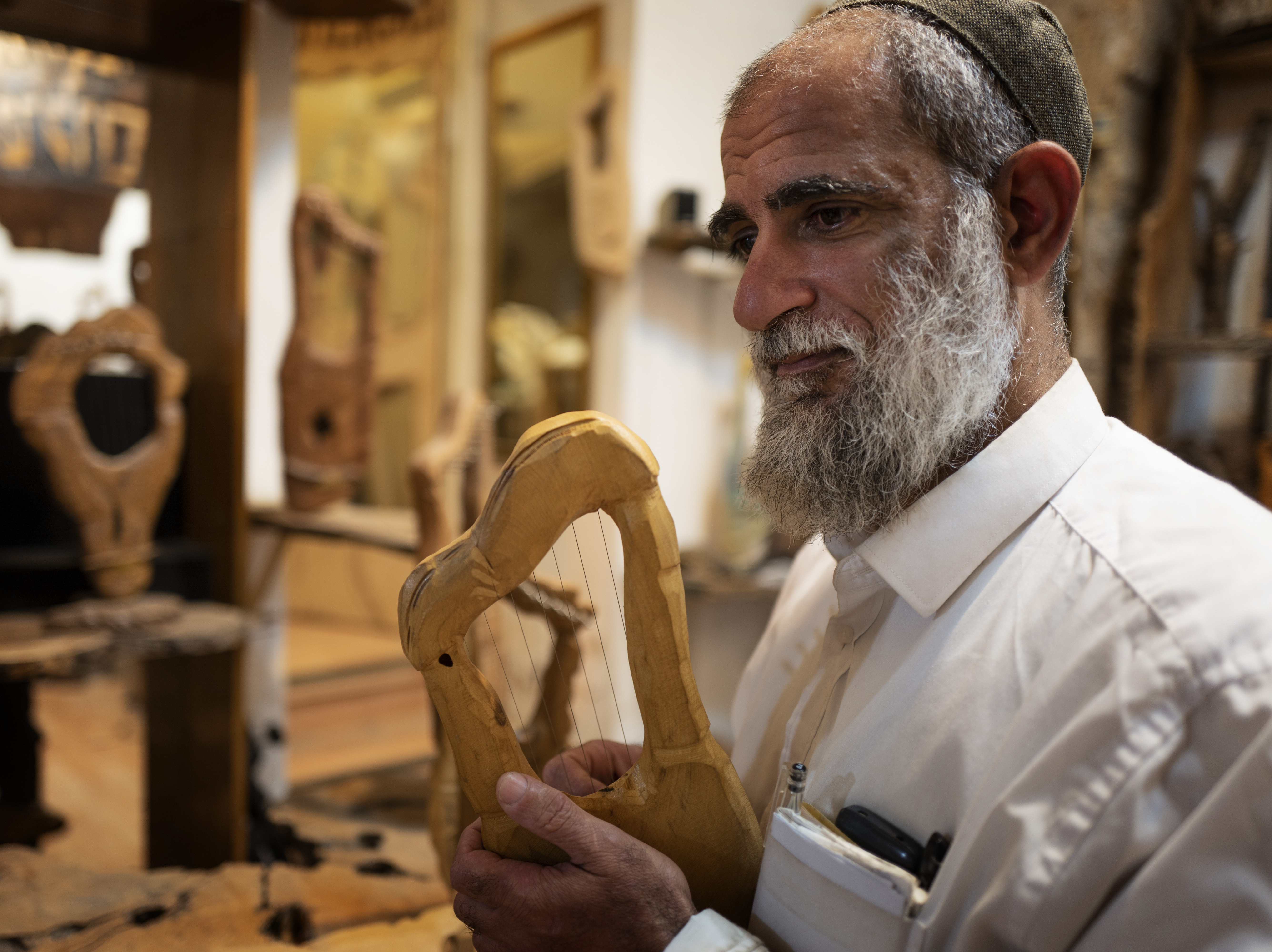 caption: Itay Levy makes music and Kinnors — intricately-carved wooden harps.