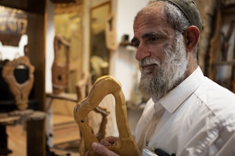 caption: Itay Levy makes music and Kinnors — intricately-carved wooden harps.