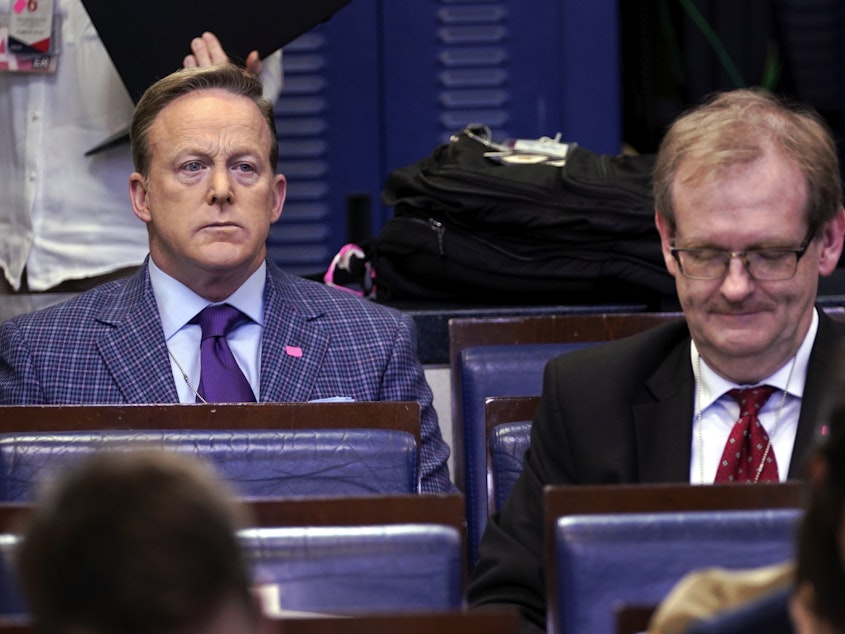caption: Sean Spicer (left), the former White House press secretary and an on-air personality for Newsmax, listens during a March coronavirus task force briefing at the White House.