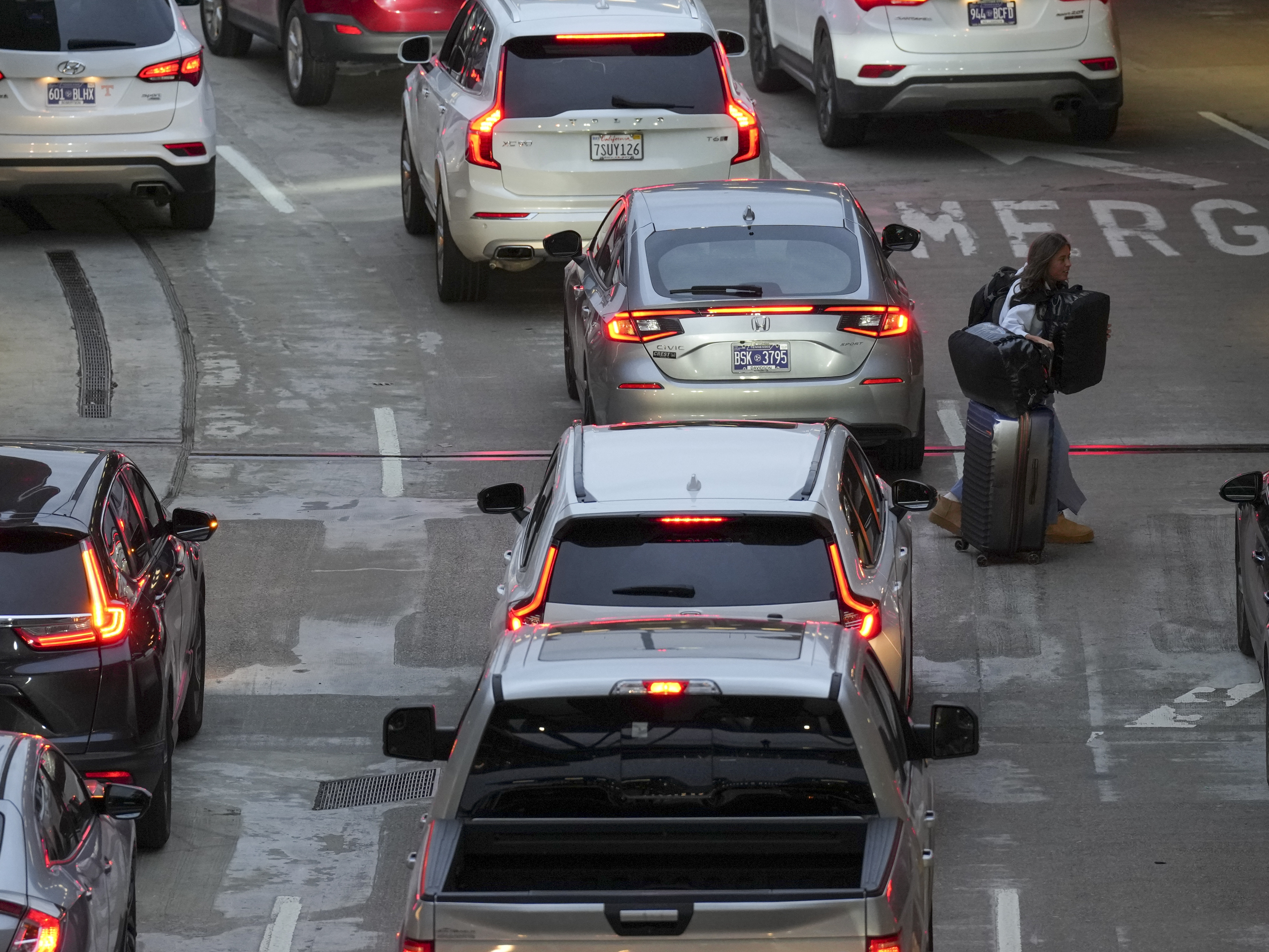 caption: A traveler makes their way into the Nashville International Airport, Friday, Dec. 20, 2024, in Nashville, Tenn.
