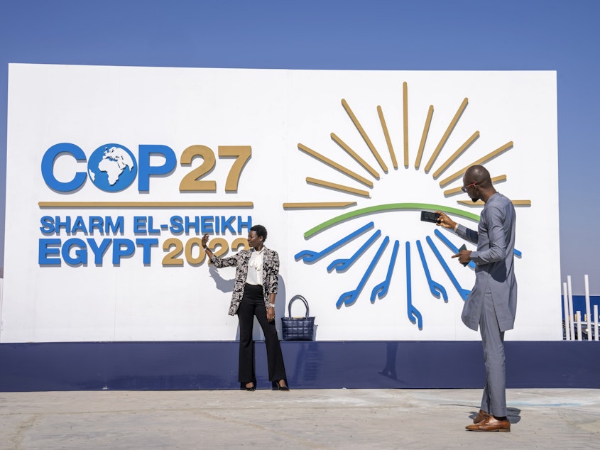 caption: A Chadian poses for a photograph at the entrance of the COP27 U.N. Climate Summit on Sunday in Sharm el-Sheikh, Egypt.