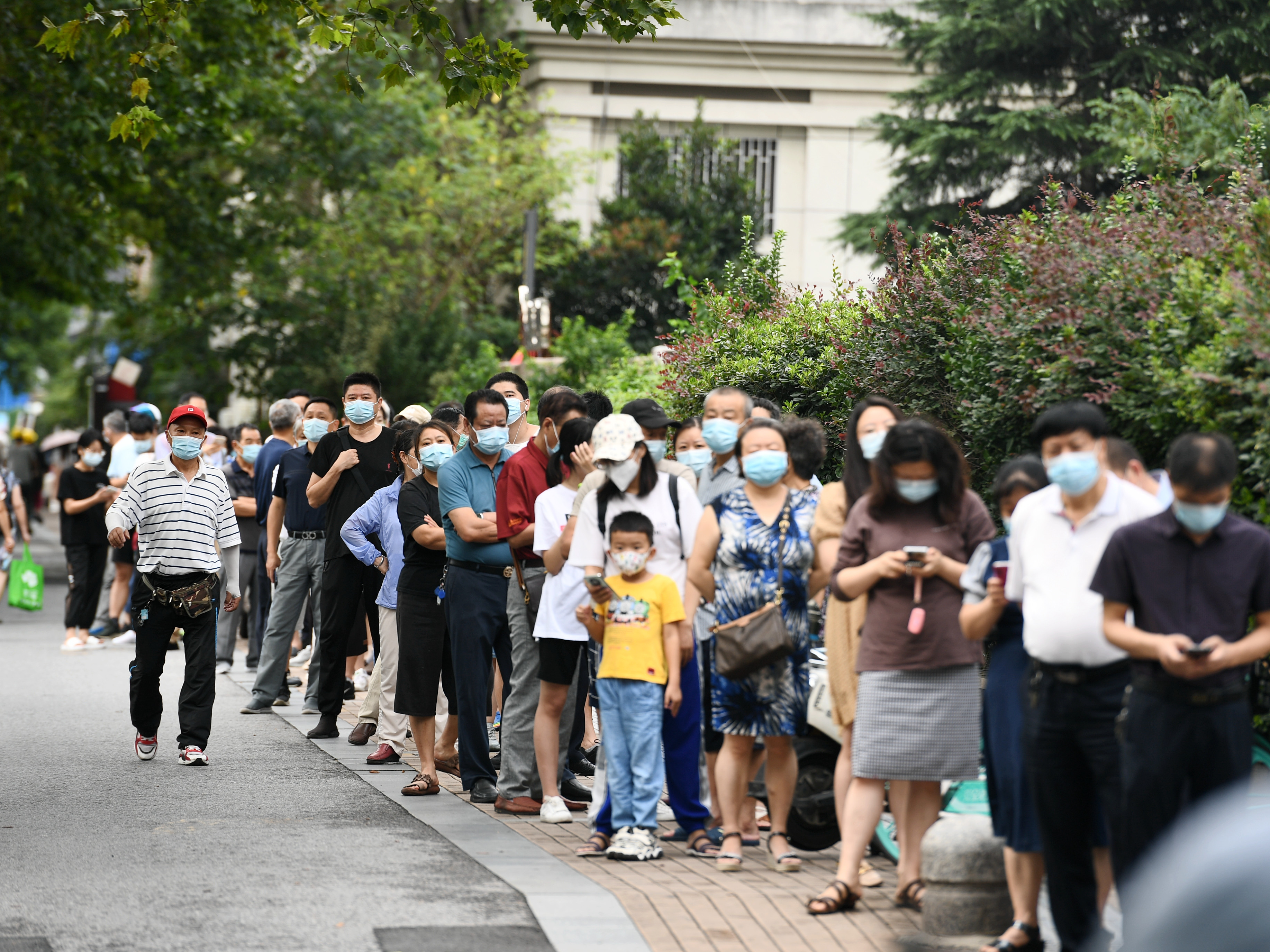 caption: People line up for coronavirus testing on Thursday in Nanjing, in China's Jiangsu province.