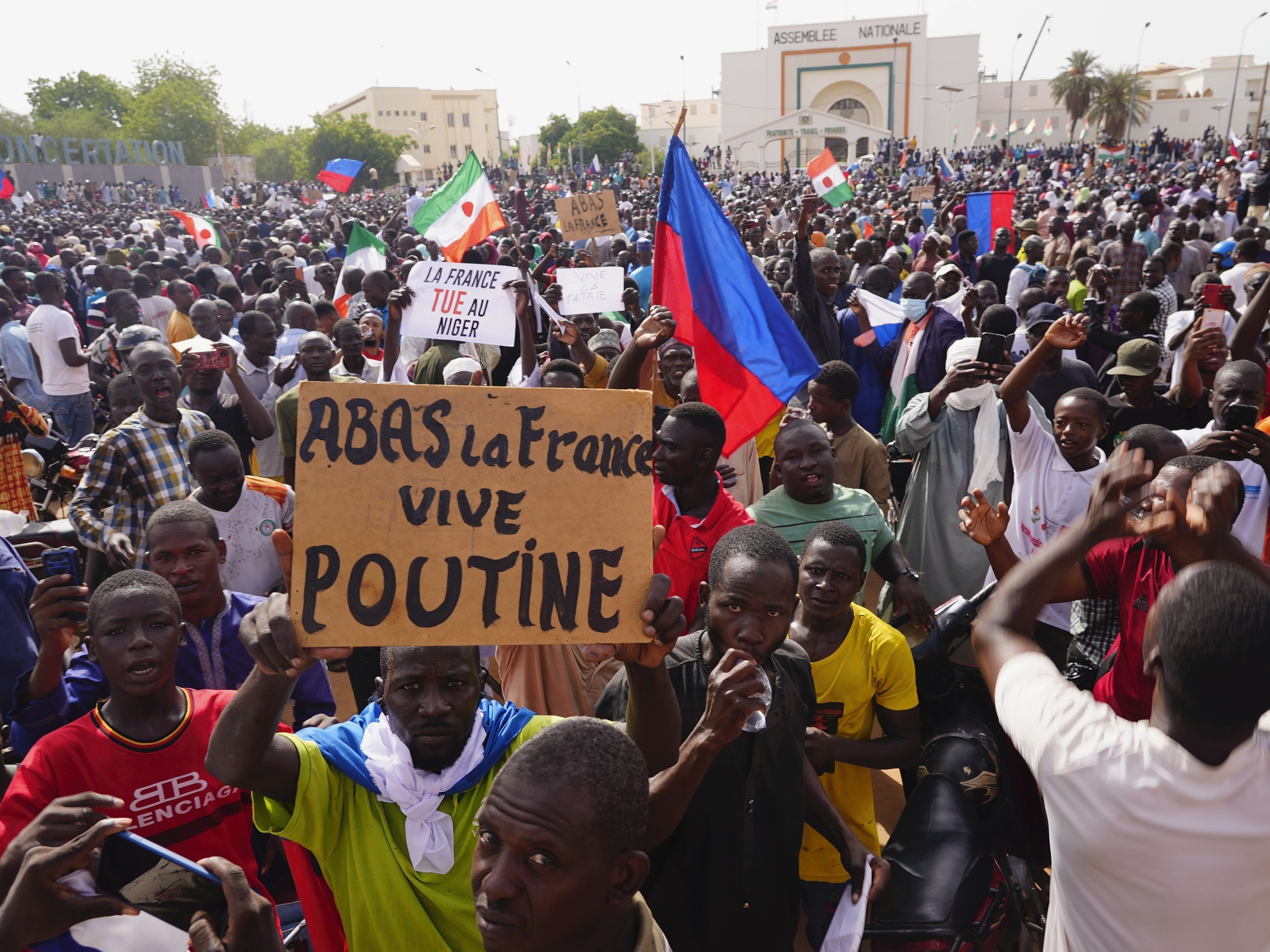 caption: Nigeriens participate in a march called by supporters of coup leader Gen. Abdourahmane Tchiani in Niamey, Niger, Sunday, July 30, 2023. Days after mutinous soldiers ousted Niger's democratically elected president, uncertainty is mounting about the country's future and some are calling out the junta's reasons for seizing control. The sign reads: "Down with France, long live Putin."