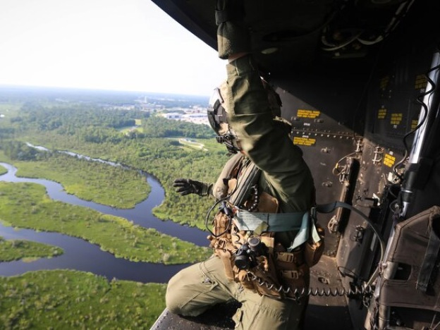 caption: <em>A crew chief with Marine Light Attack Helicopter Squadron 167, 2nd Marine Aircraft Wing, rides in the back of a UH-1Y Venom as it approaches a landing zone during a training exercise near Camp Lejeune, North Carolina, on June 17th, 2016.</em>