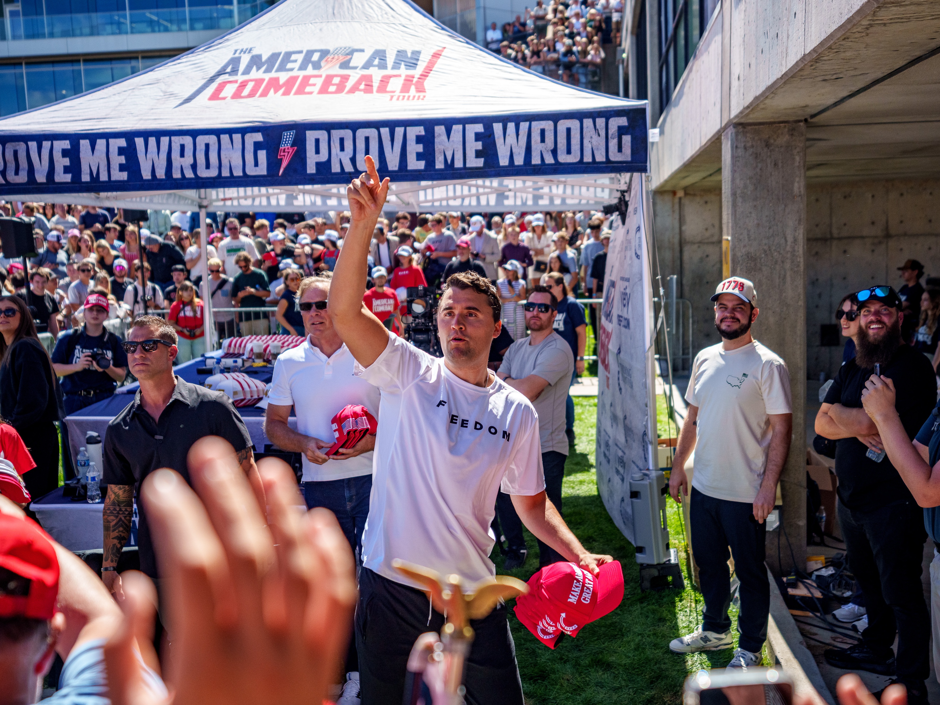 caption: Charlie Kirk throws hats to the crowd after arriving at Utah Valley University on Wednesday for a stop on his "American Comeback Tour." He was fatally shot less than an hour later.