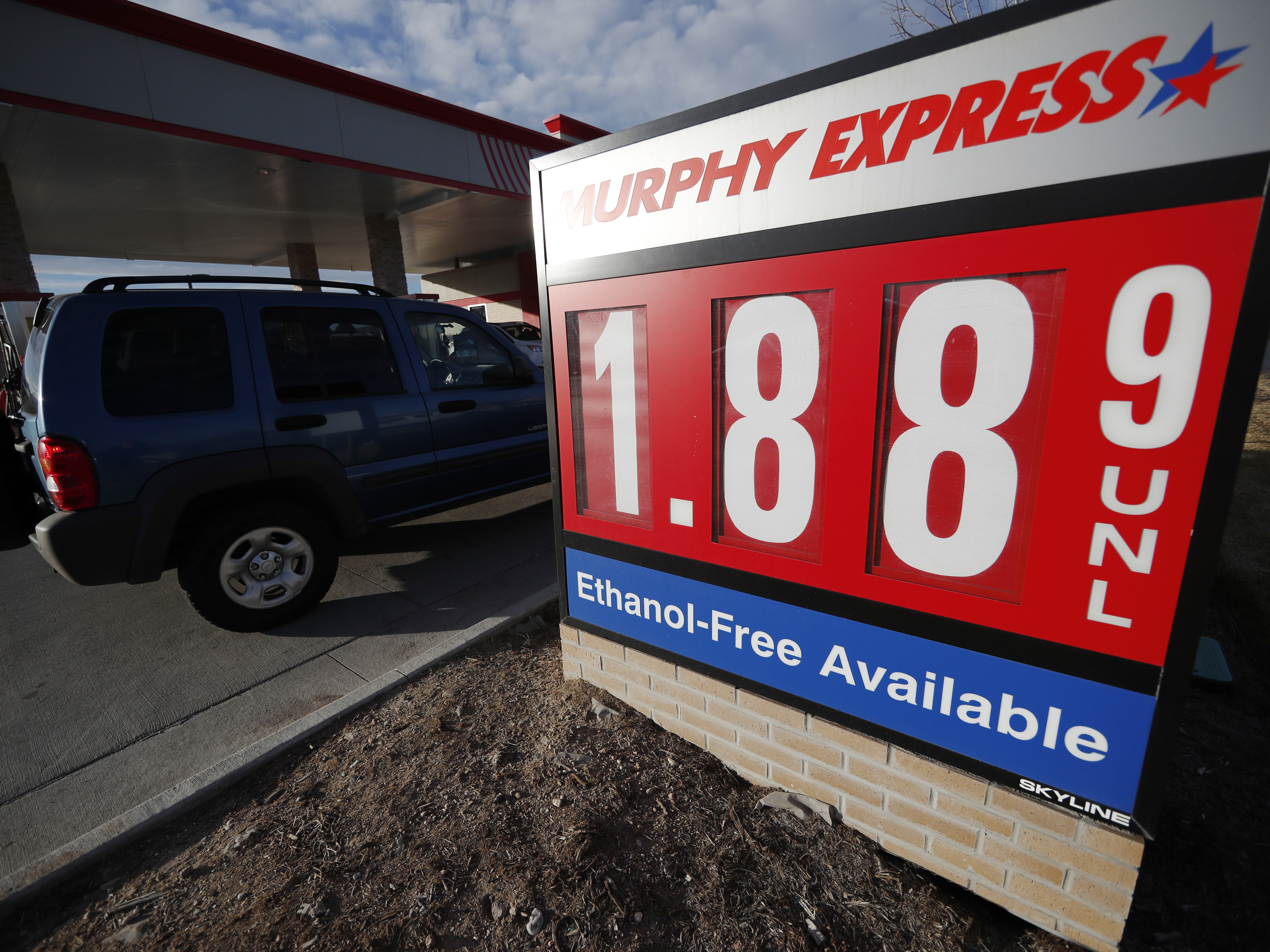 caption: Motorists drive past a sign advertising regular gasoline at $1.88 per gallon at a station in Longmont, Colo., on Dec. 22, 2018. Falling gasoline prices have given drivers a little extra cheer this winter.