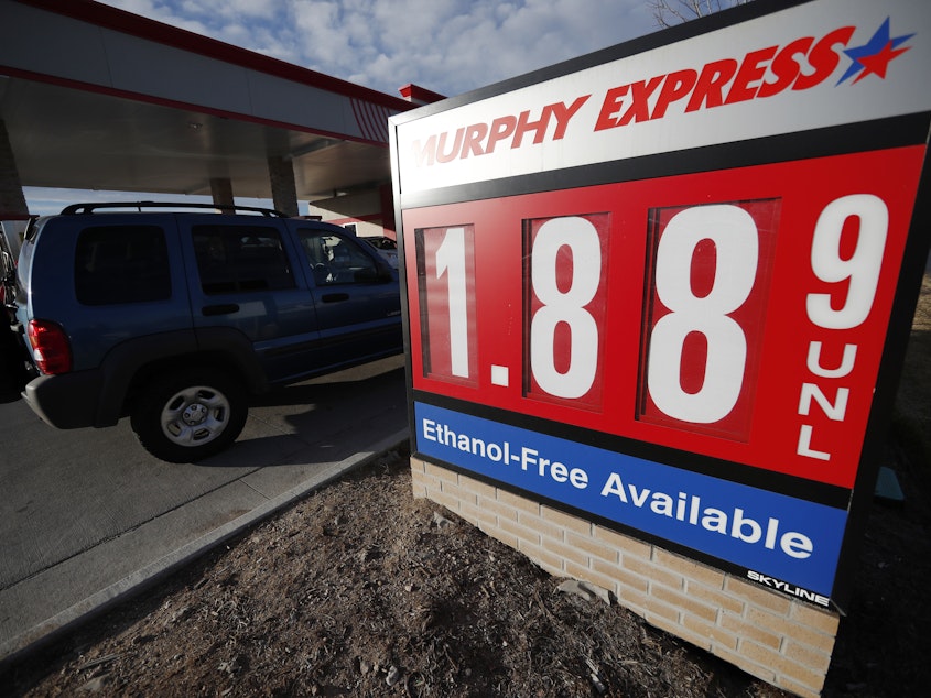 caption: Motorists drive past a sign advertising regular gasoline at $1.88 per gallon at a station in Longmont, Colo., on Dec. 22, 2018. Falling gasoline prices have given drivers a little extra cheer this winter.