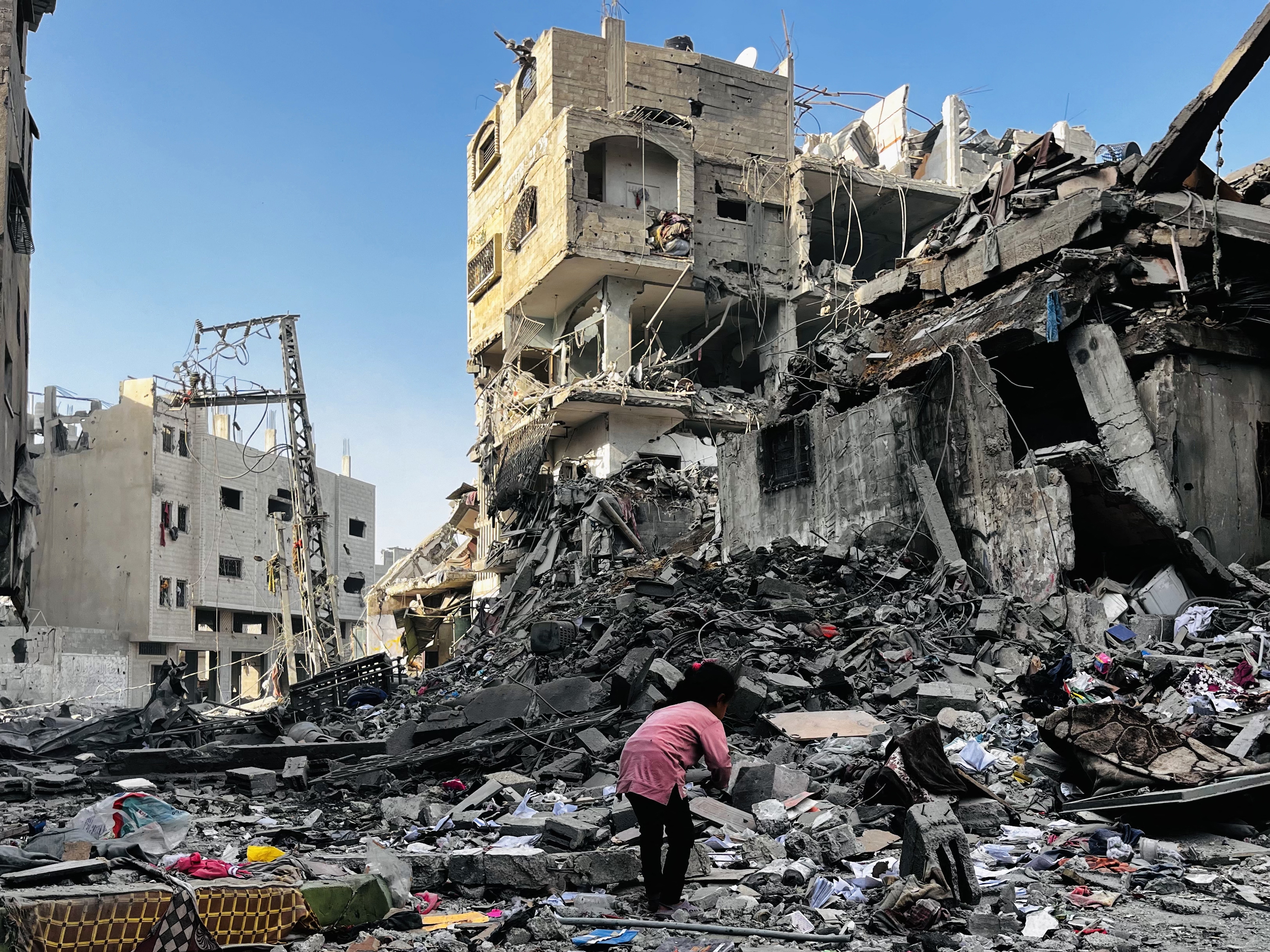 caption: A Palestinian girl searches in the rubble of a building after an Israeli strike in Beit Lahiya, in the northern Gaza Strip, on Tuesday.