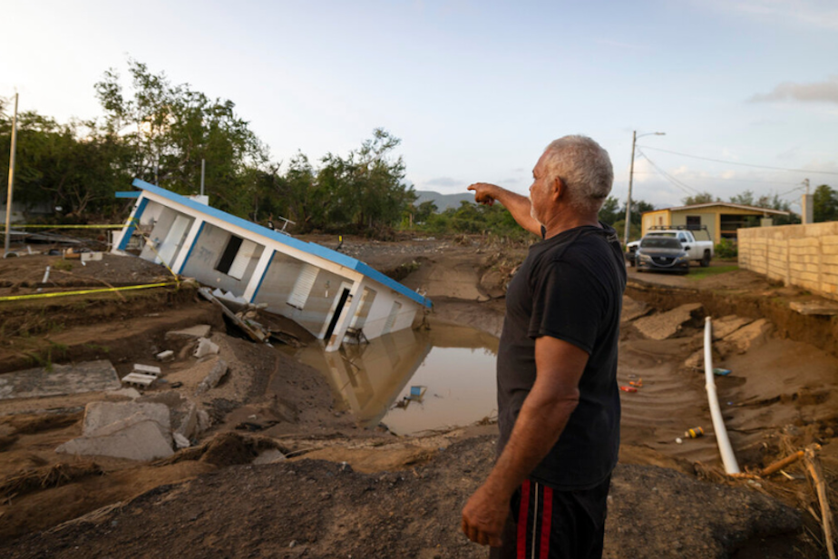 caption: A man points to a home that was collapsed by Hurricane Fiona at Villa Esperanza in Salinas, Puerto Rico, Wednesday, September 21, 2022. 