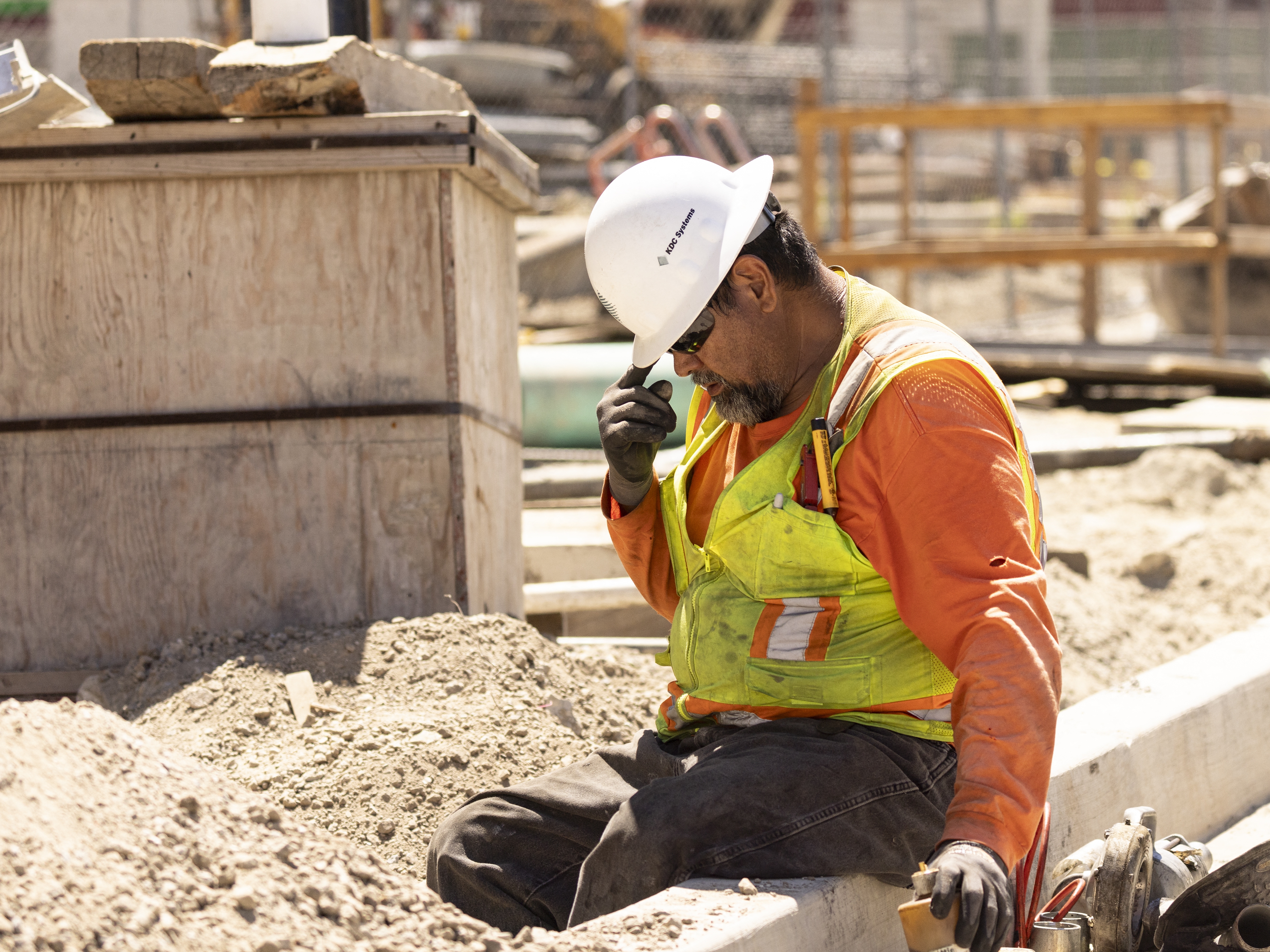 caption: A worker adjusts his helmet on a construction site under the sun as southern California faces a heat wave, in Los Angeles, on Wednesday.