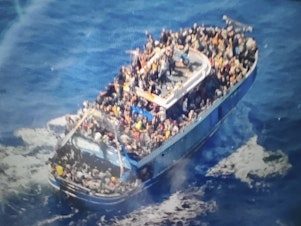 caption: This handout image provided by Greece's coast guard on June 14 shows scores of people on a battered fishing boat that later capsized and sank off southern Greece, drowning hundreds of migrants.