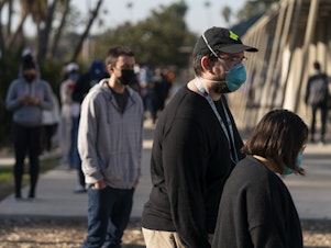 caption: People wait in line for a coronavirus test in Los Angeles on Tuesday. California is starting to feel the full wrath of the omicron variant. Hospitalizations have jumped nearly 50% since Christmas and models show that in a month, the state could have 22,000 people in hospitals, which was the peak during last winter's epic surge.