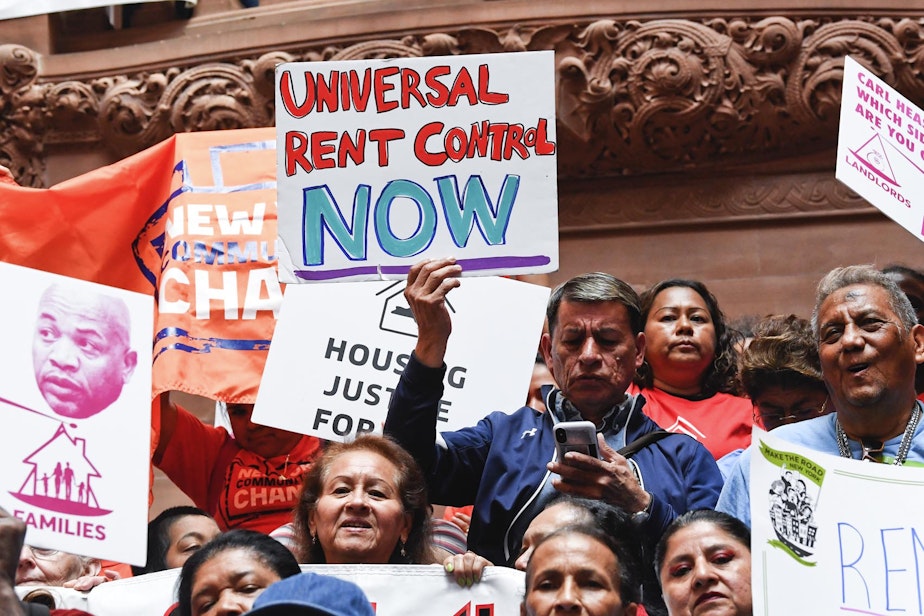 caption: Tenants and members of the Upstate Downstate Housing Alliance from across the state demand New York Gov. Andrew Cuomo and state legislators pass universal rent control legislation at the state Capitol Tuesday, June 4, 2019, in Albany, N.Y. (Hans Pennink/AP)