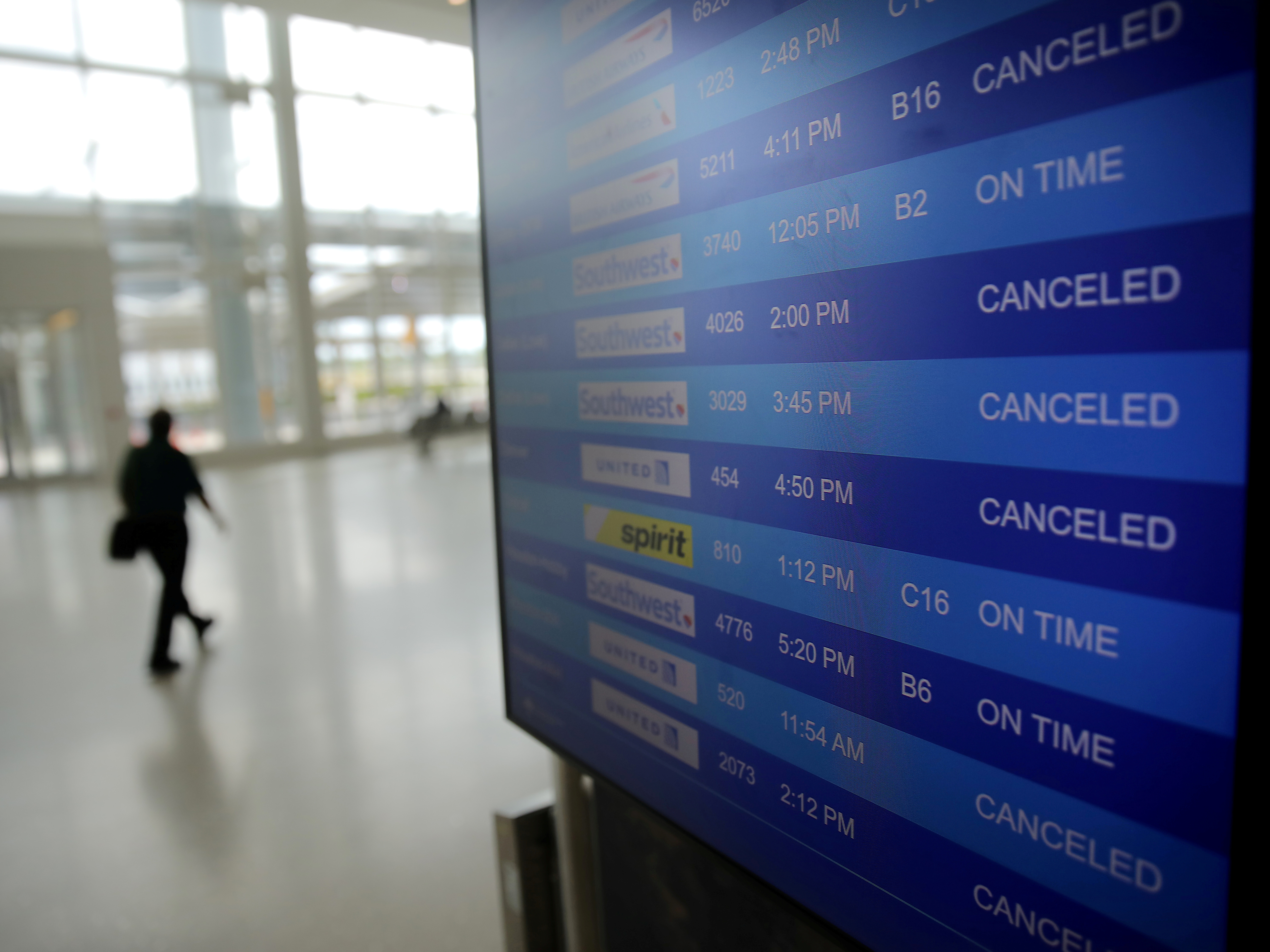 caption: The plunge in demand for air travel during the coronavirus crisis is reflected on an airport screen in New Orleans on April 4.