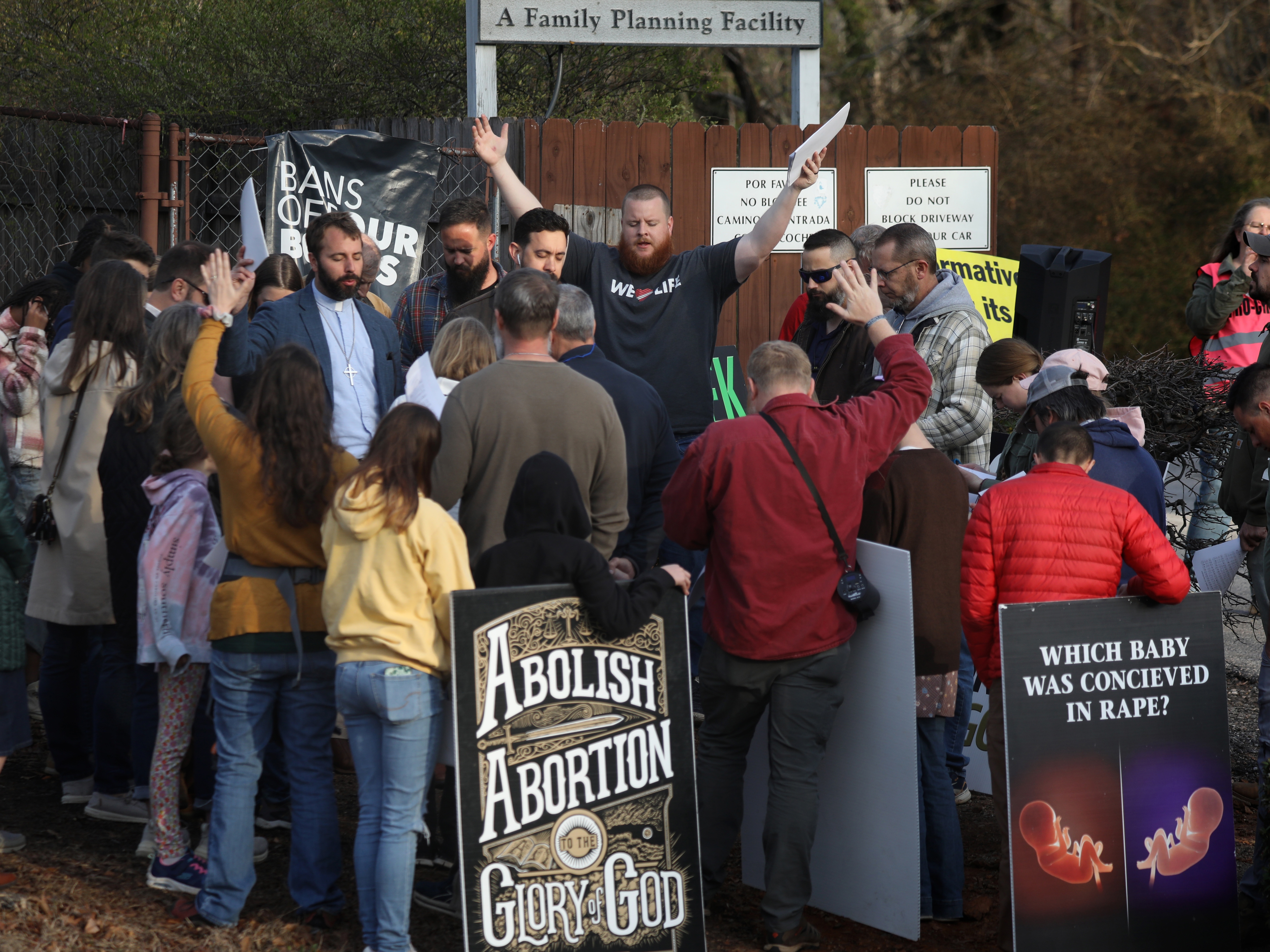 caption: Anti-abortion activists pray and protest in front of the Greenville Women's Clinic in Greenville, S.C., in March.