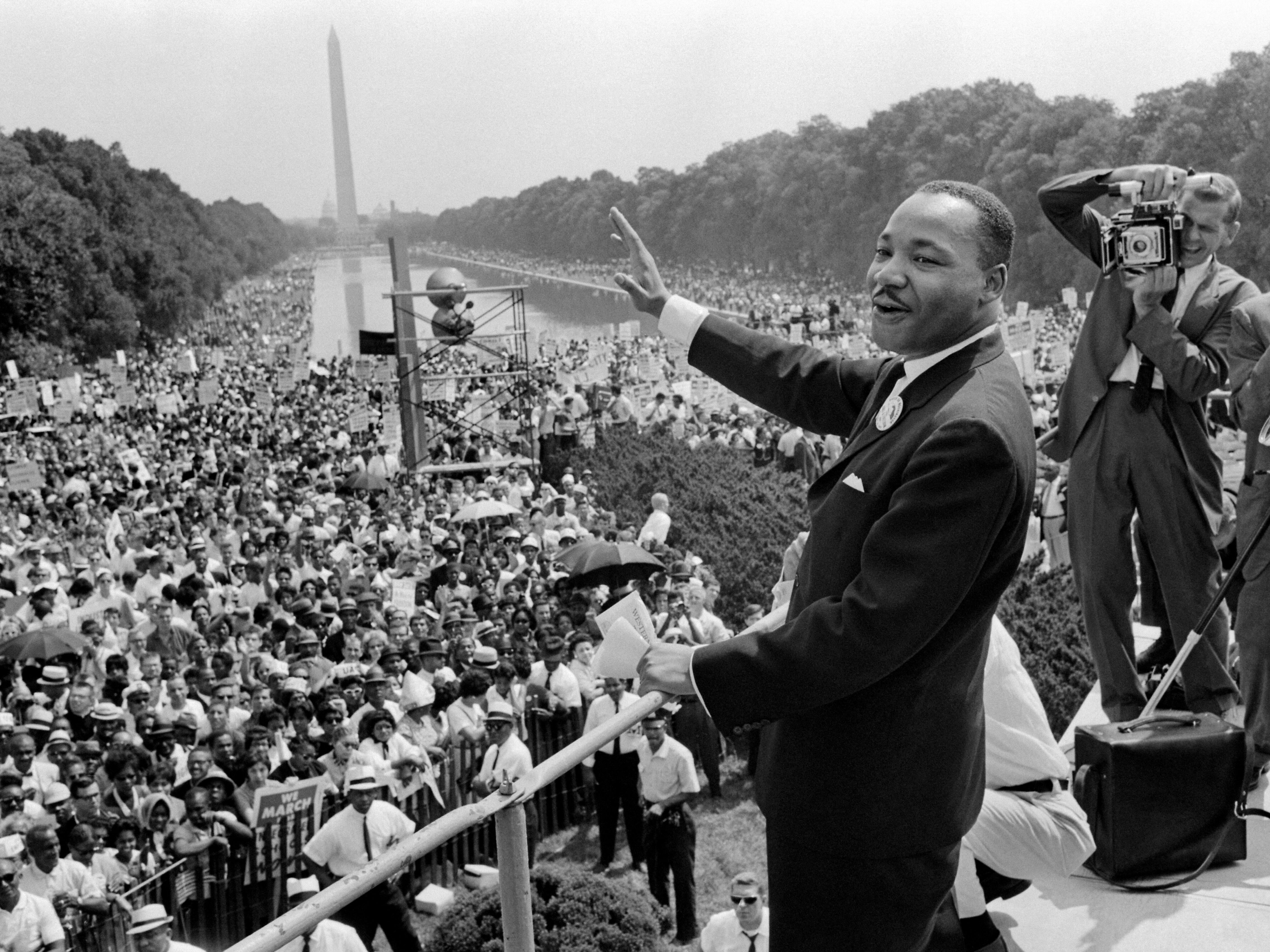 caption: Martin Luther King Jr. waves to the crowd during the "March on Washington" in 1963.