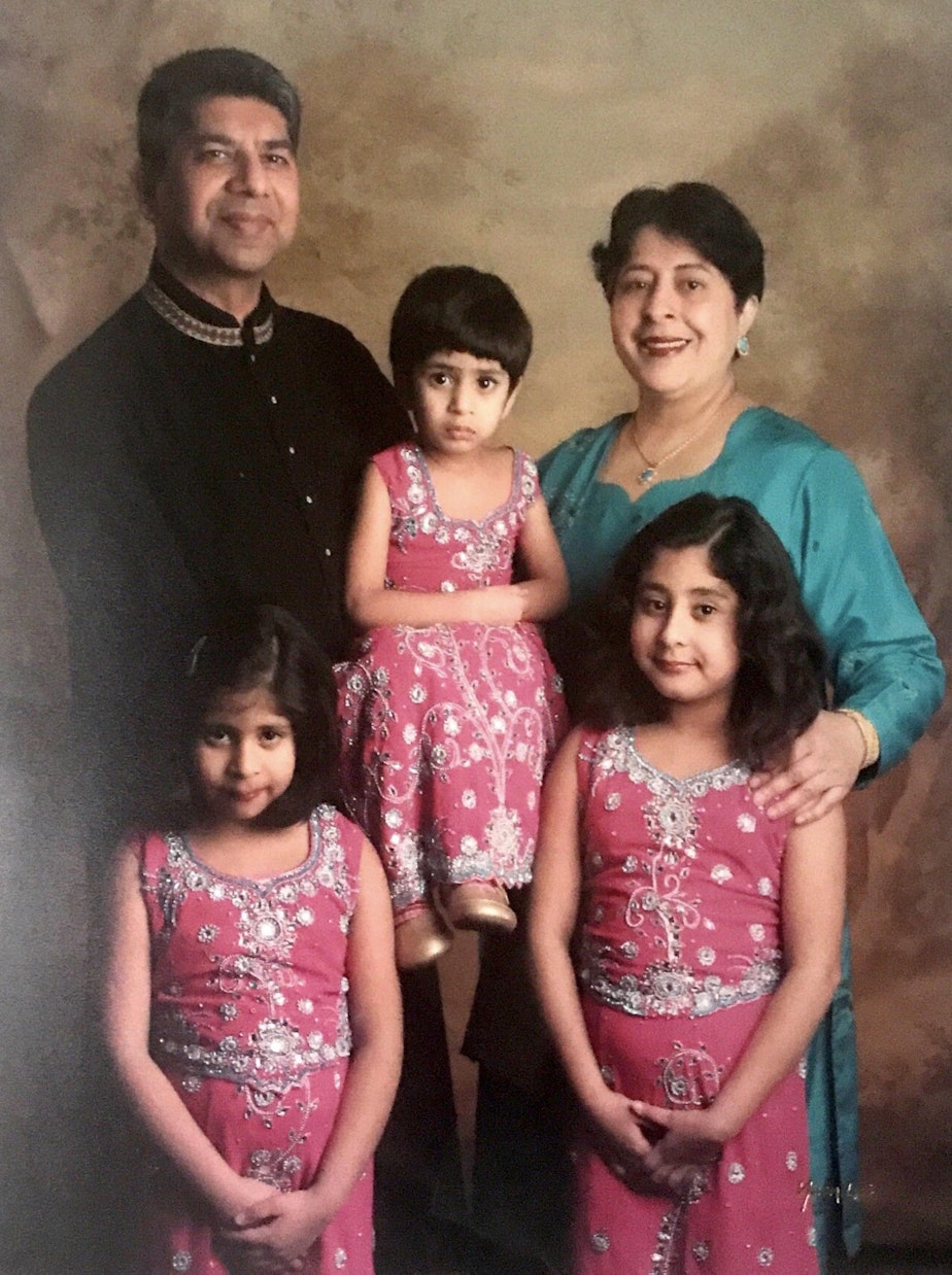 caption: A photo of the Ali family from when Huma (bottom left), Saba (center) and their oldest sister Heather were children.