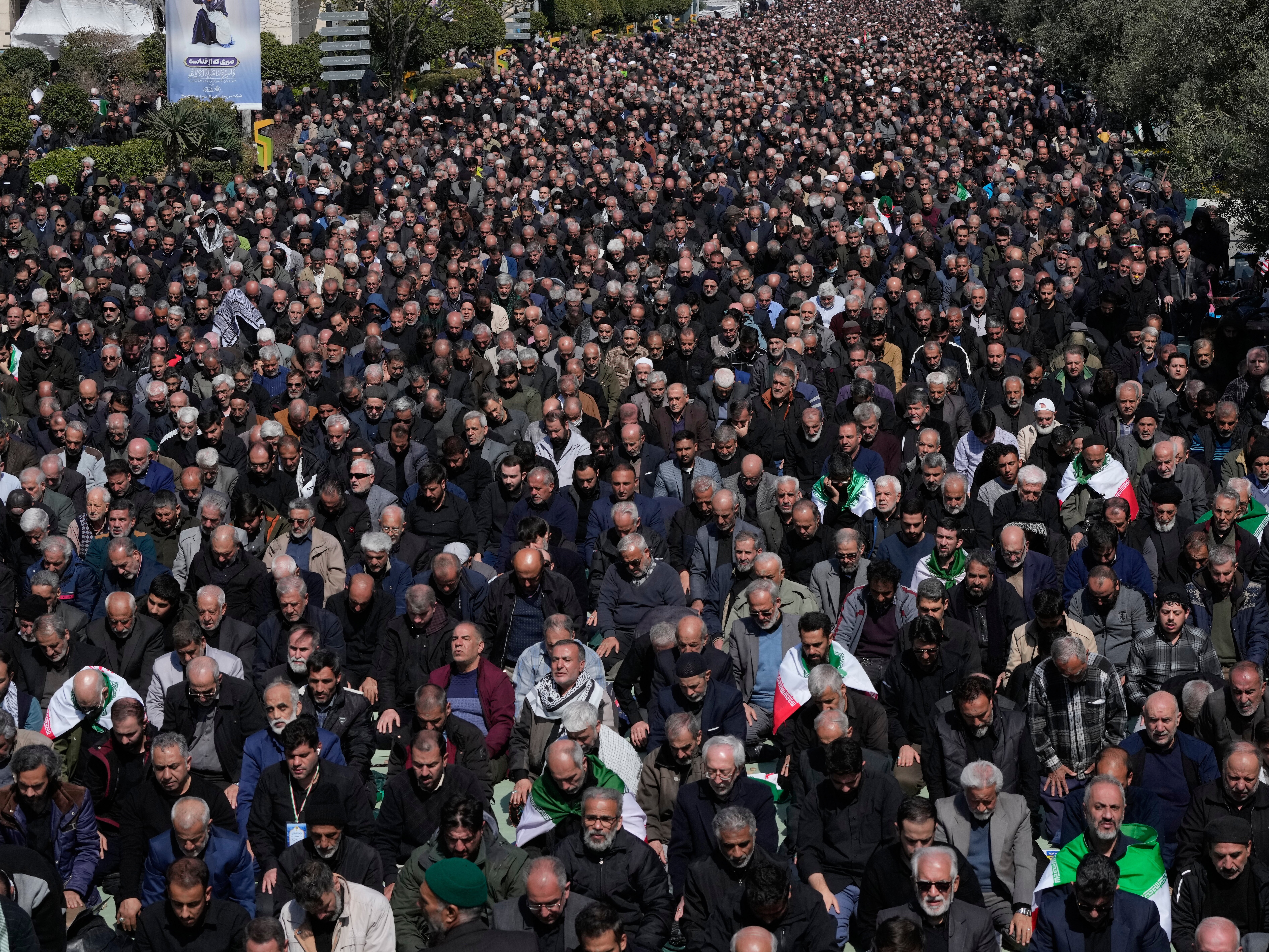 caption: Iranians attend Friday prayers in the courtyard of the Imam Khomeini Grand mosque in Tehran, Iran, Friday, March 6, 2026.