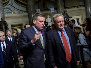 caption: Sens. Mark Warner and Mike Crapo, seen here making their way to the House chamber for President Trump's first State of the Union Address in 2018, are announcing an effort to expand access to capital for small businesses emerging from the pandemic.