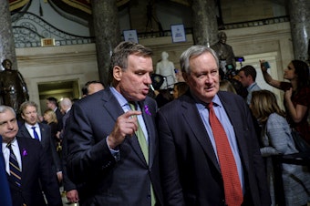 caption: Sens. Mark Warner and Mike Crapo, seen here making their way to the House chamber for President Trump's first State of the Union Address in 2018, are announcing an effort to expand access to capital for small businesses emerging from the pandemic.