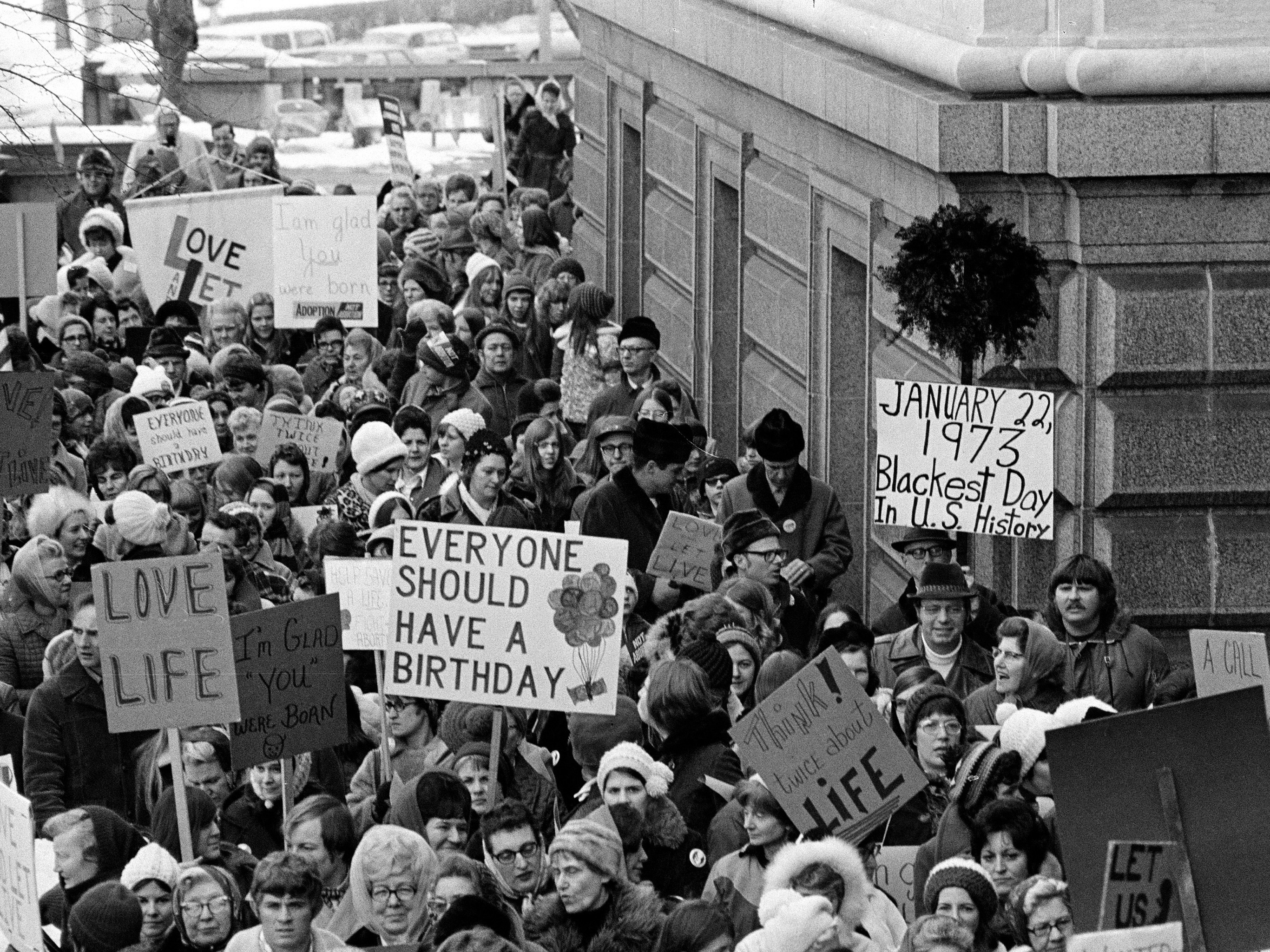 caption: People march around the Minnesota Capitol building protesting the U.S. Supreme Court's Roe v. Wade decision in St. Paul, Minn., in January.