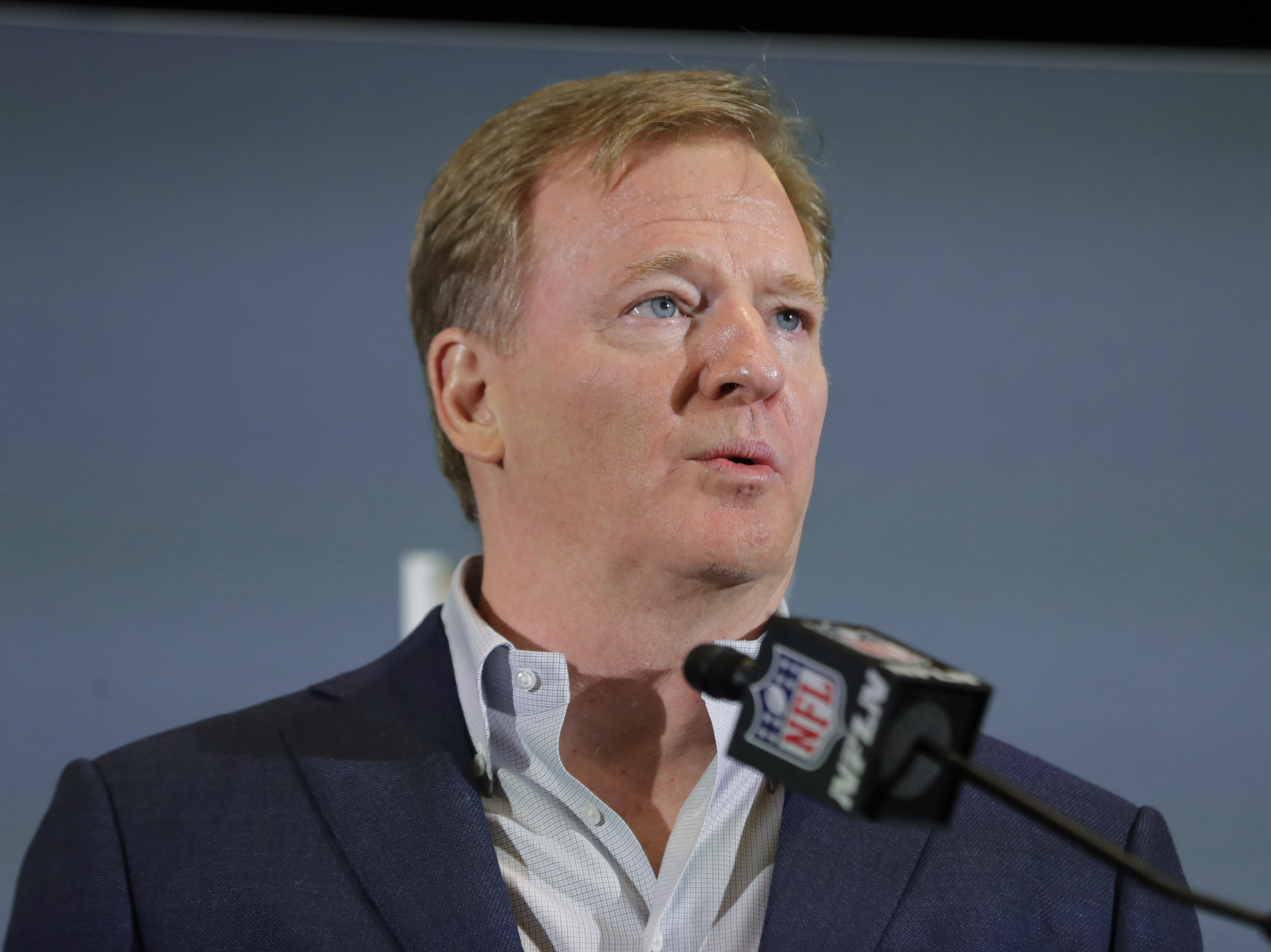 caption: The NFL has set protocols for reopening team facilities, a process that begins as early as Tuesday. NFL Commissioner Roger Goodell is shown here speaking in Miami in February.