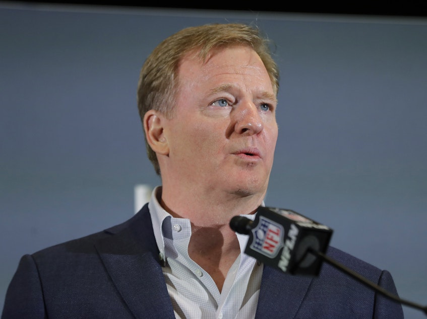 caption: The NFL has set protocols for reopening team facilities, a process that begins as early as Tuesday. NFL Commissioner Roger Goodell is shown here speaking in Miami in February.