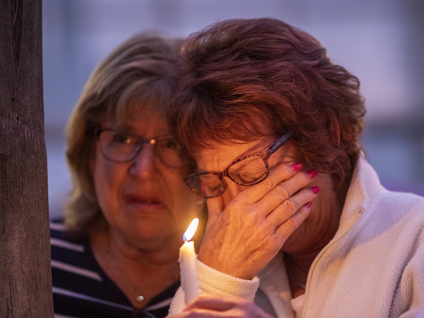 caption: People attend a prayer and candlelight vigil for victims of a synagogue shooting at nearby Rancho Bernardo Community Presbyterian Church in Poway, Calif., on Saturday.