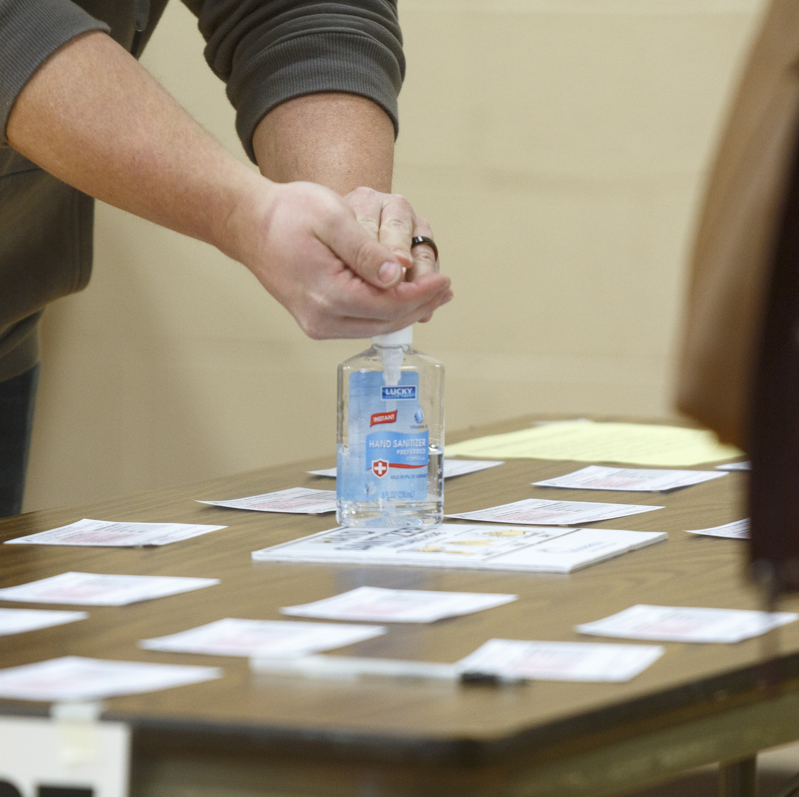 caption: A Michigan voter uses hand sanitizer that the polling place provided after casting his ballot at Warren Woods Baptist Church in Warren, Mich., last week.