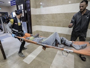 caption: Palestinians injured in Israeli raids arrive at Nasser Medical Hospital on Tuesday in Khan Younis, Gaza.