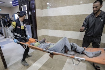 caption: Palestinians injured in Israeli raids arrive at Nasser Medical Hospital on Tuesday in Khan Younis, Gaza.