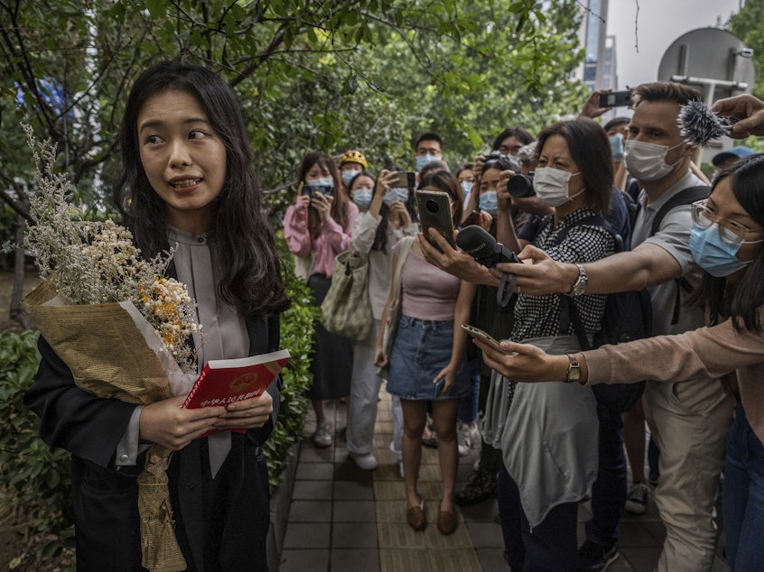 caption: Zhou Xiaoxuan speaks to journalists and supporters on Sept. 14 outside the Haidian District People's Court in Beijing before a hearing in her case. She alleged that she was groped and forcibly kissed by prominent TV anchor Zhu Jun, who denies the allegations and has countersued for defamation. The court ruled there was not sufficient evidence of sexual harassment.