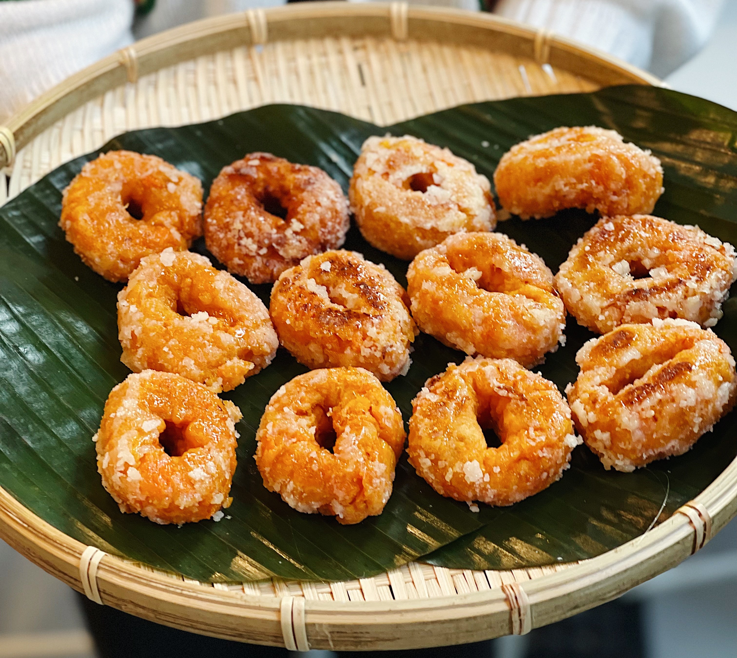 caption: Freshly made Kuih keria, a fried sweet potato doughnut, sit on a plate at Masakan. 