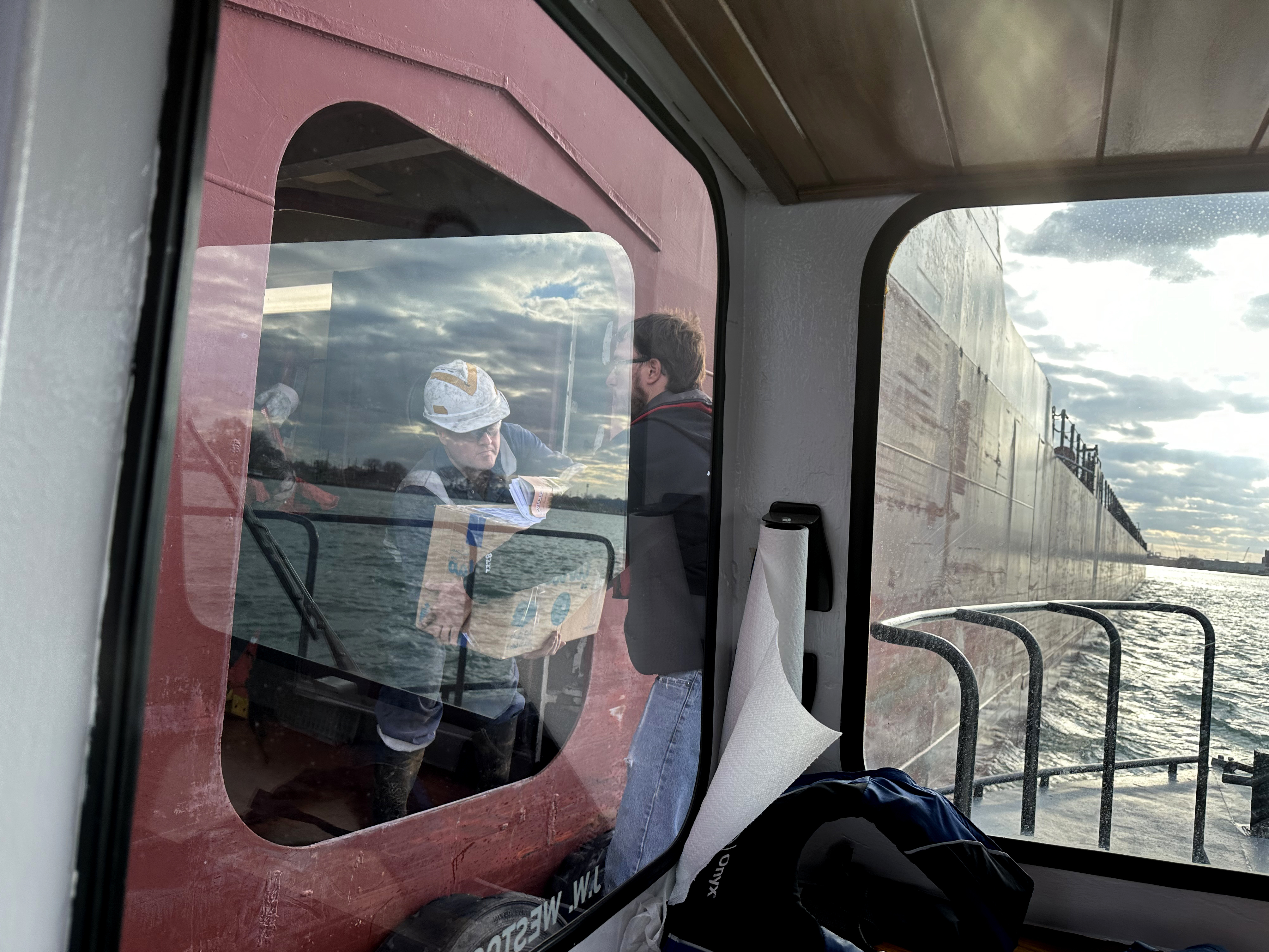 caption: Sailors on the Great Republic, a Great Lakes bulk cargo carrier built in 1981, receive their mail on the Detroit River.