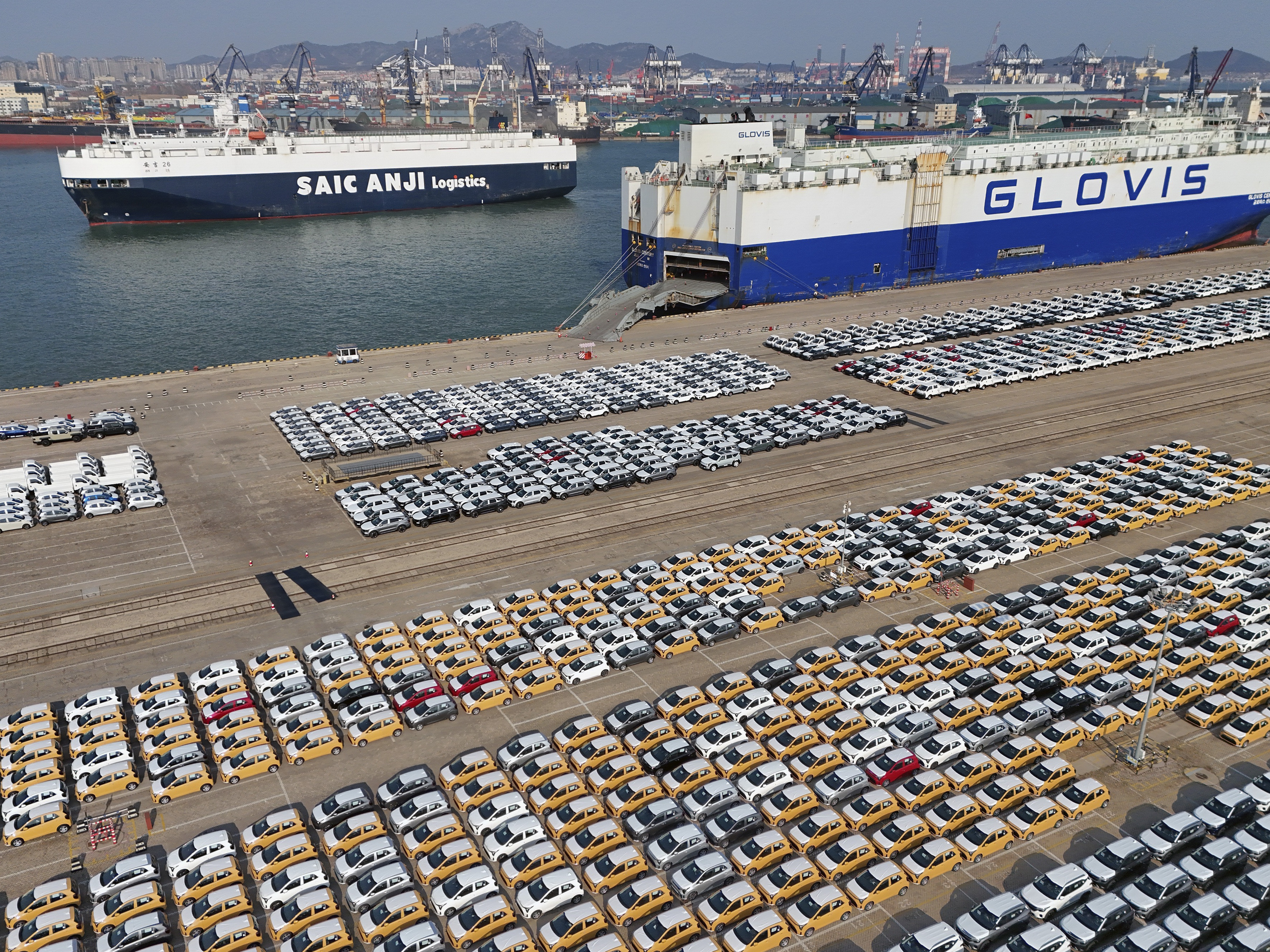 caption: Vehicles and trucks for export wait for transportation from a port in Yantai in eastern China's Shandong province on Jan. 2, 2025.