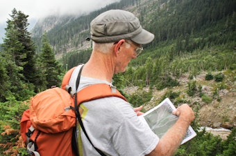 caption: Dan Miller, a geomorphologist, hikes to a potential debris field in the North Cascades to look for signs in the landscape of landslides. 