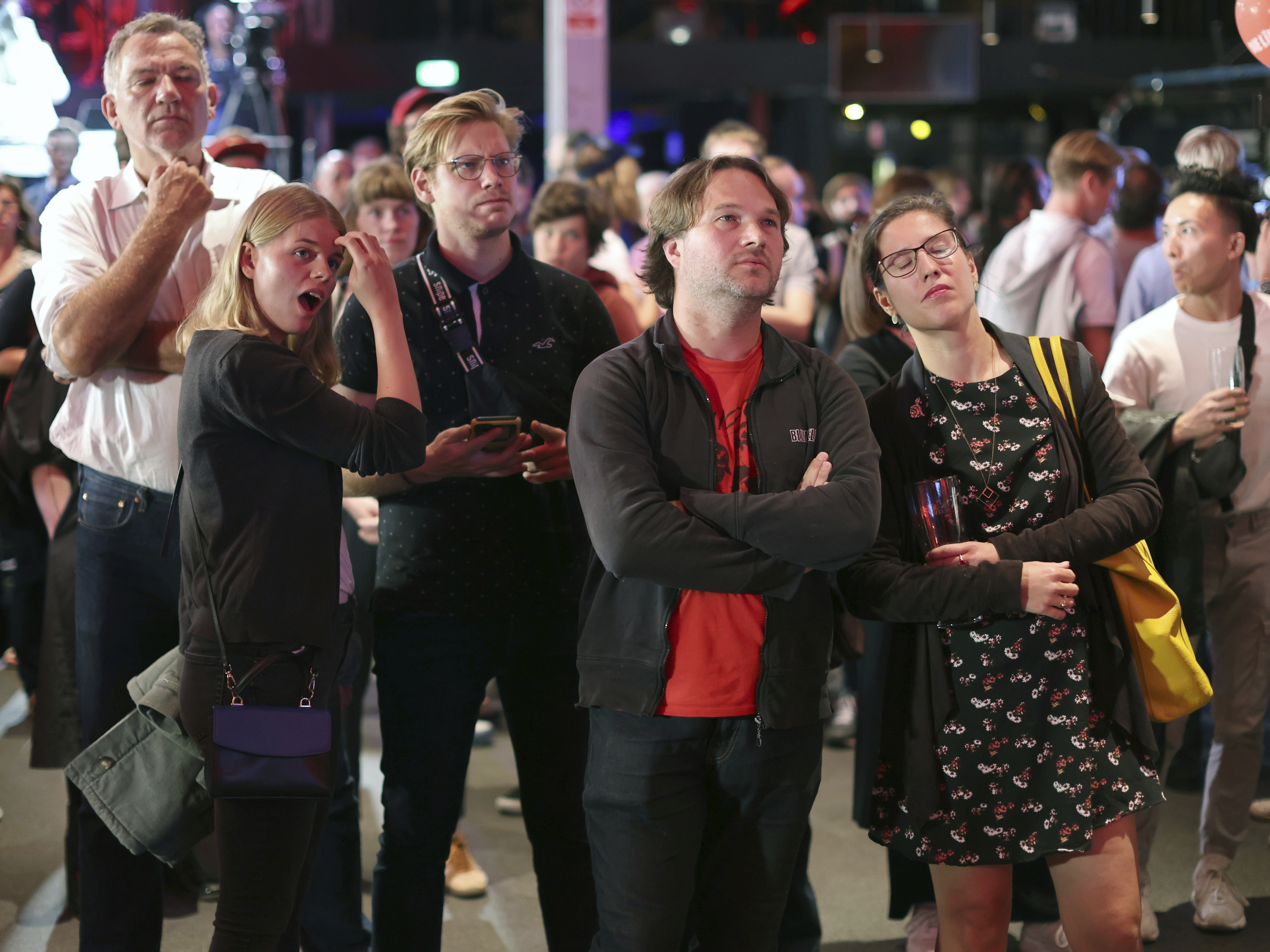 caption: Guests at the election party of Die Linke react at the Karl-Liebknecht-Haus after the publication of the first forecasts on the outcome of the 2021 federal election, in Berlin on Sunday.
